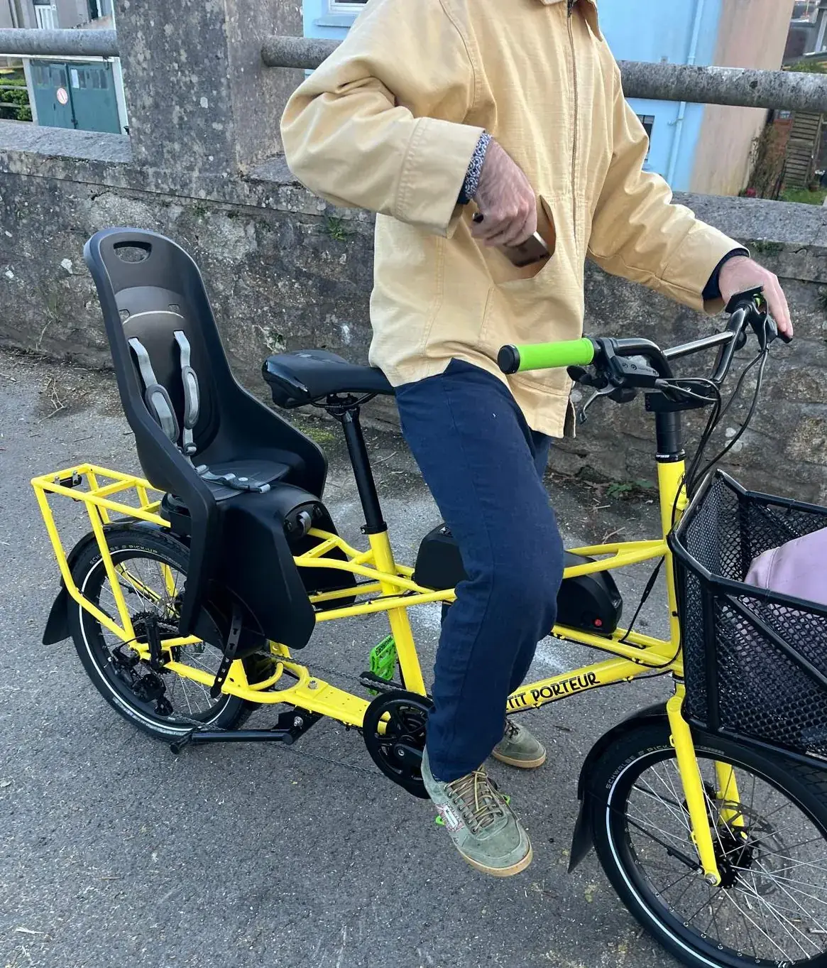 Vélo cargo jaune équipé d'un siège enfant, dans une rue de Brest