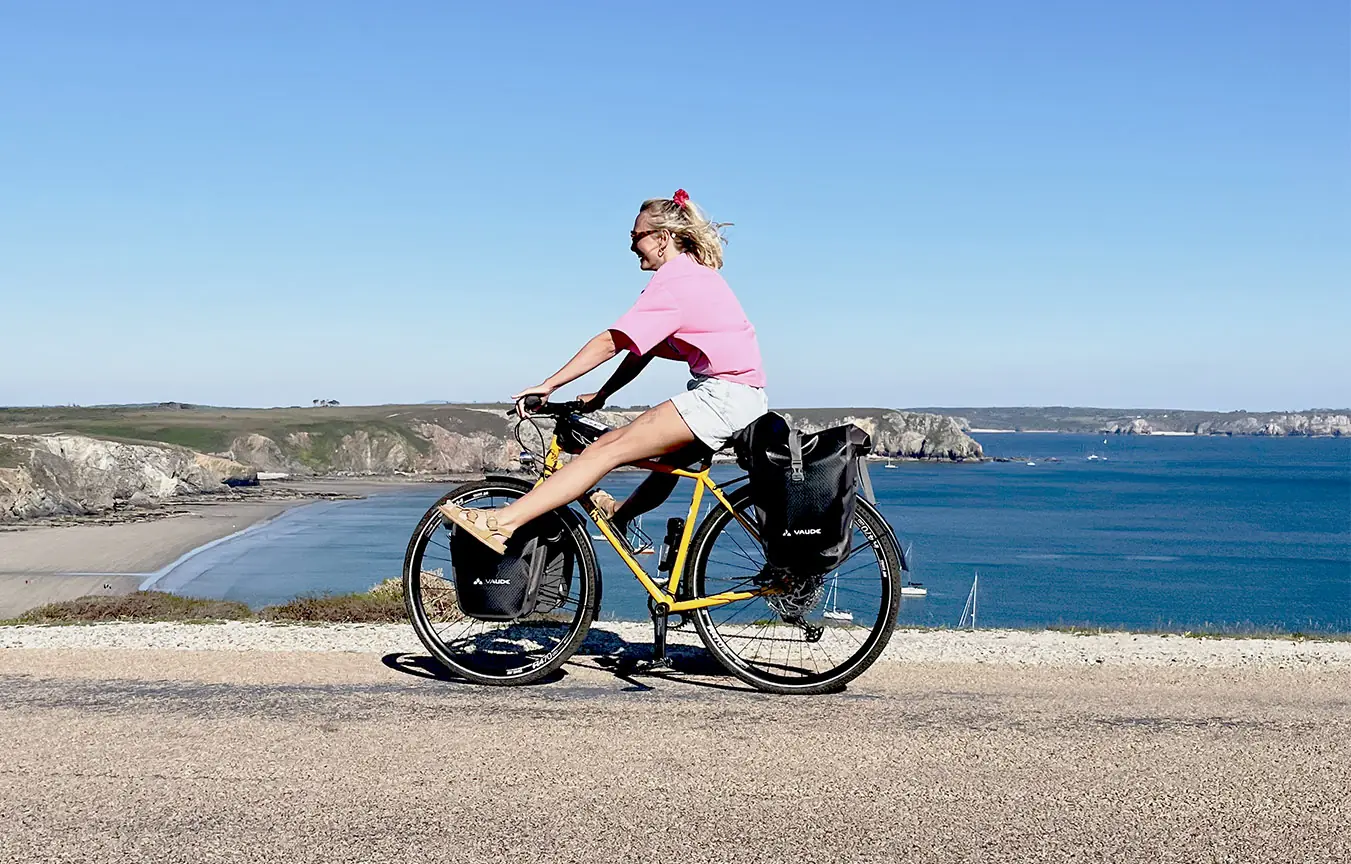 Cycliste sur un vélo chargé de sacoches, le long de la côte finistérienne