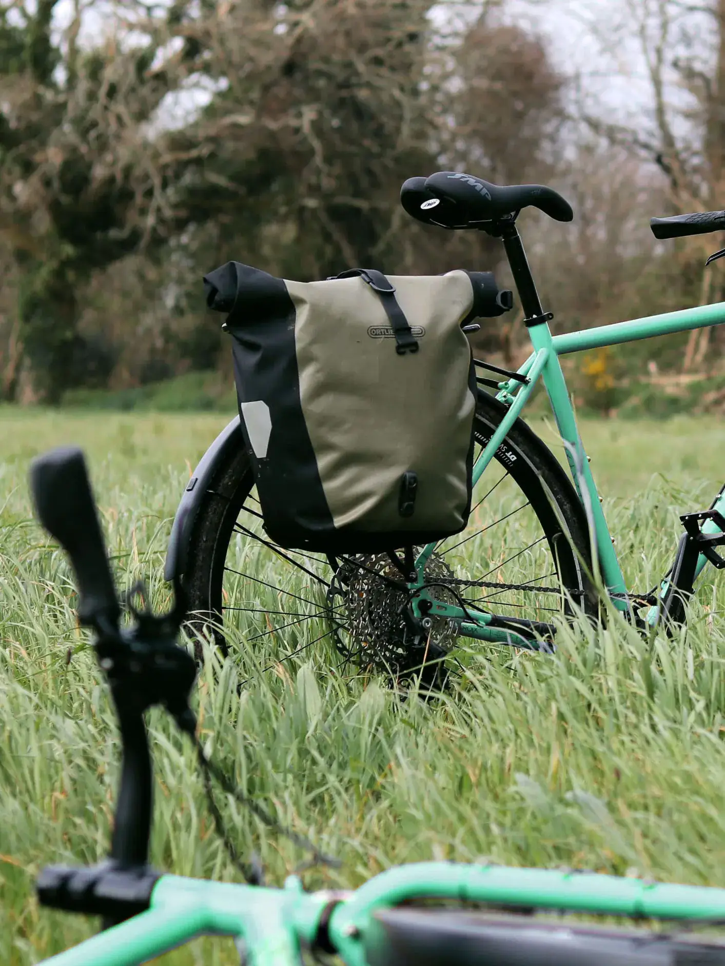Vélo de voyage vert d'eau chargé d'une sacoche arrière